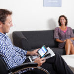 Persoon leest tijdschrift in de woonkamer met behulp van Compact 7 HD