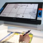 Optelec Traveller HD Stand in gebruik voor het maken van kruiswoordpuzzels