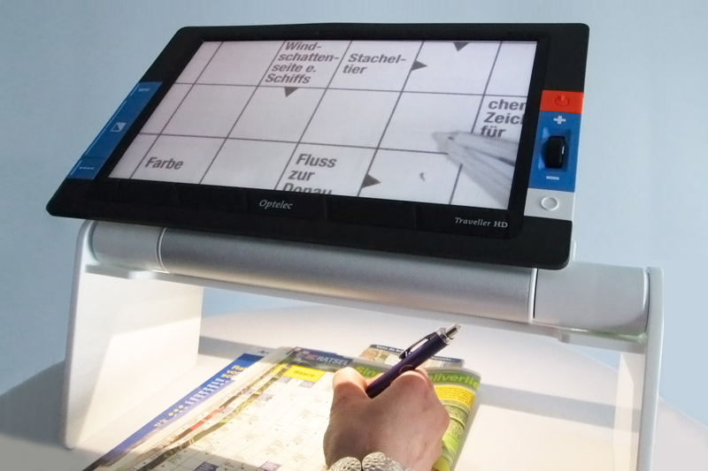Optelec Traveller HD Stand in gebruik voor het maken van kruiswoordpuzzels