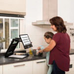 Clearview Go being used in the kitchen ti magnify a recipe by a lady and young girl, possibly her daughter