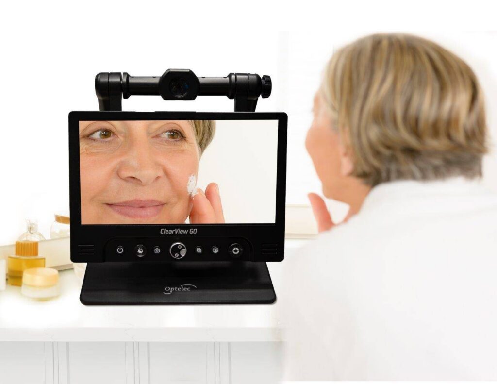 An elderly lady using the Clearview Go to apply make up